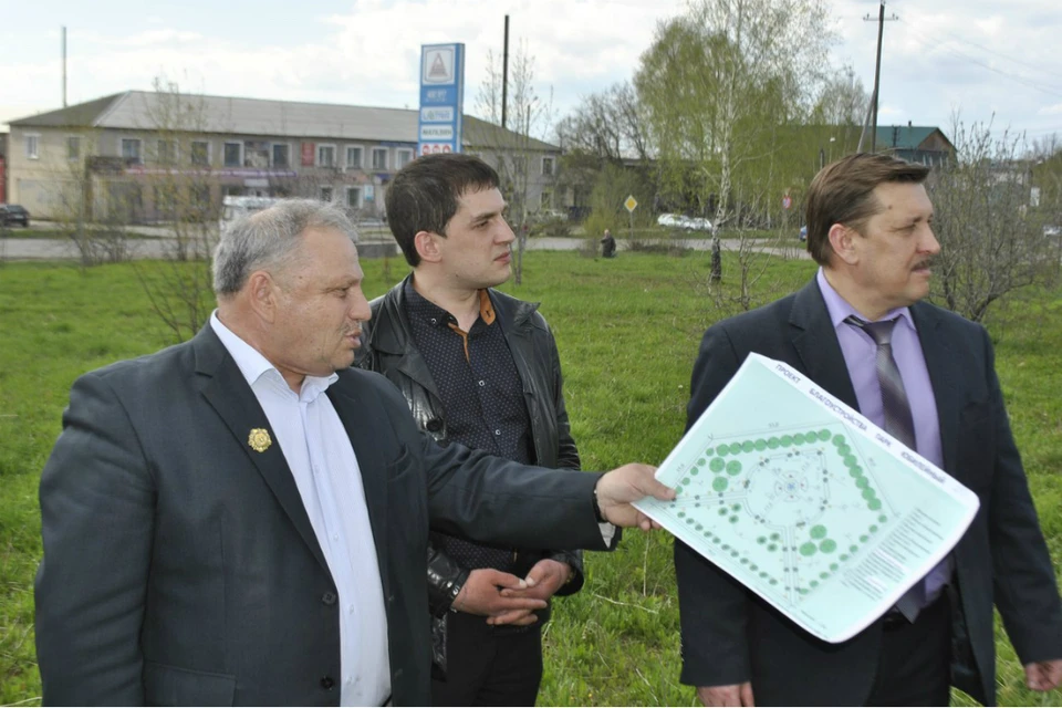 Глава администрации города Николай Малков показывает участникам рабочего совещания место будущего парка.