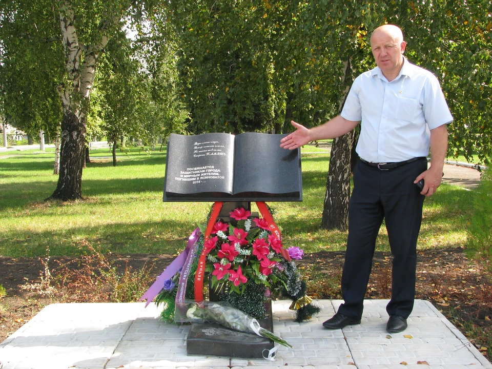 Олег Моргун на площади Славы в Ясиноватой показывает книгу памяти – монумент посвятили погибшим горожанам и защитникам Республики.