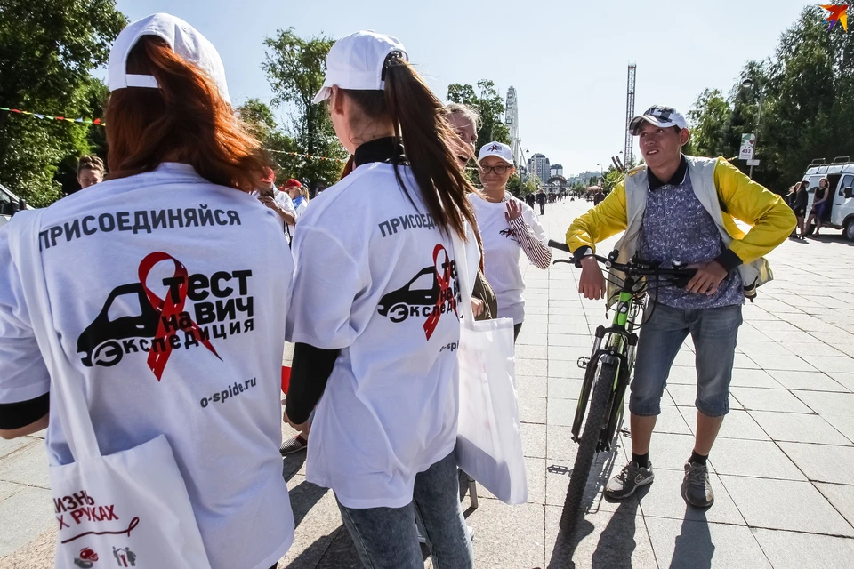 Волонтеры в белых футболках приглашают тюменцев пройти тест на ВИЧ. Фото Михаила Калянова