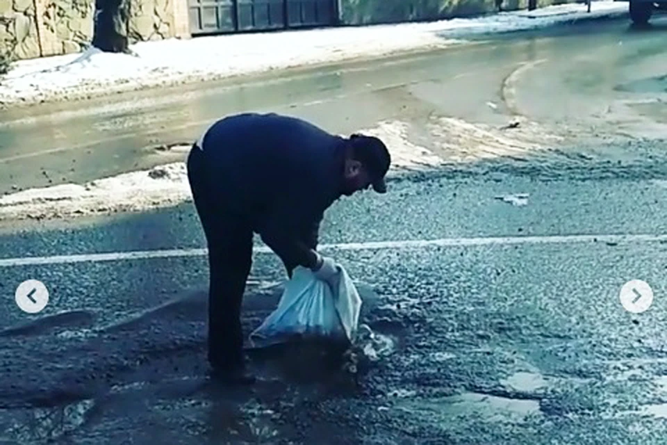 Таксист самостоятельно засыпал яму. Стоп-кадр из видео пользователя Instagram @taximen.rostov