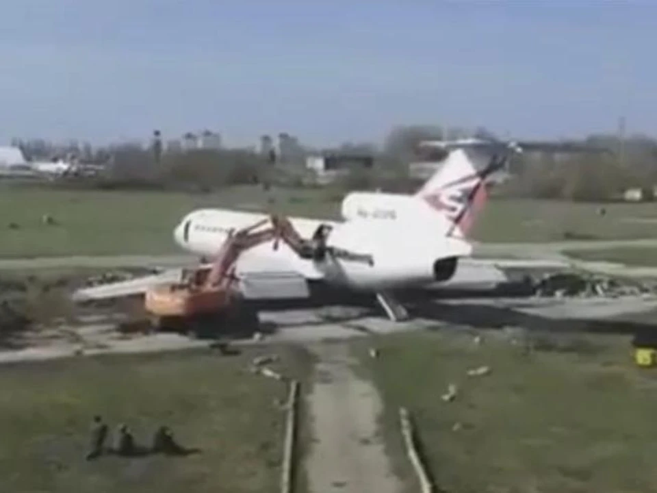 Экскаватор разрушает самолет. Кадр видео