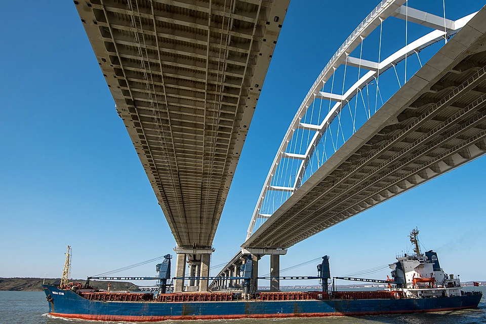 Баржа проходит под аркой Крымского моста, который соединил берега Керченского пролива.