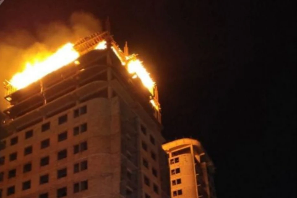 Пламя охватило верхние этажи здания.