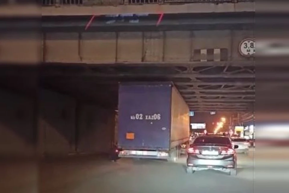 Водитель грузовика переоценил свои возможности, решив проскочить под путепроводом на Красном проспекте. Фото: Кадр из видео