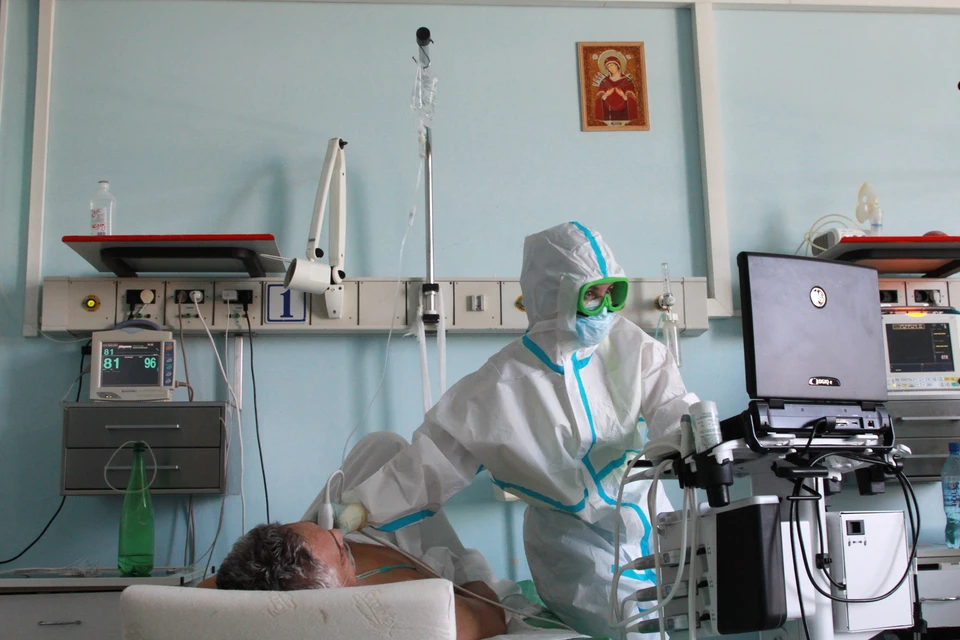 Иркутск. Городская клиническая больница №1. Врач обследует пациента отделения для зараженных коронавирусной инфекцией COVID-19.