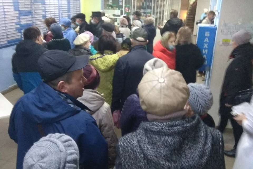 Несколько десятков человек пытаются получить талоны. Фото: Сергей Семизаров.