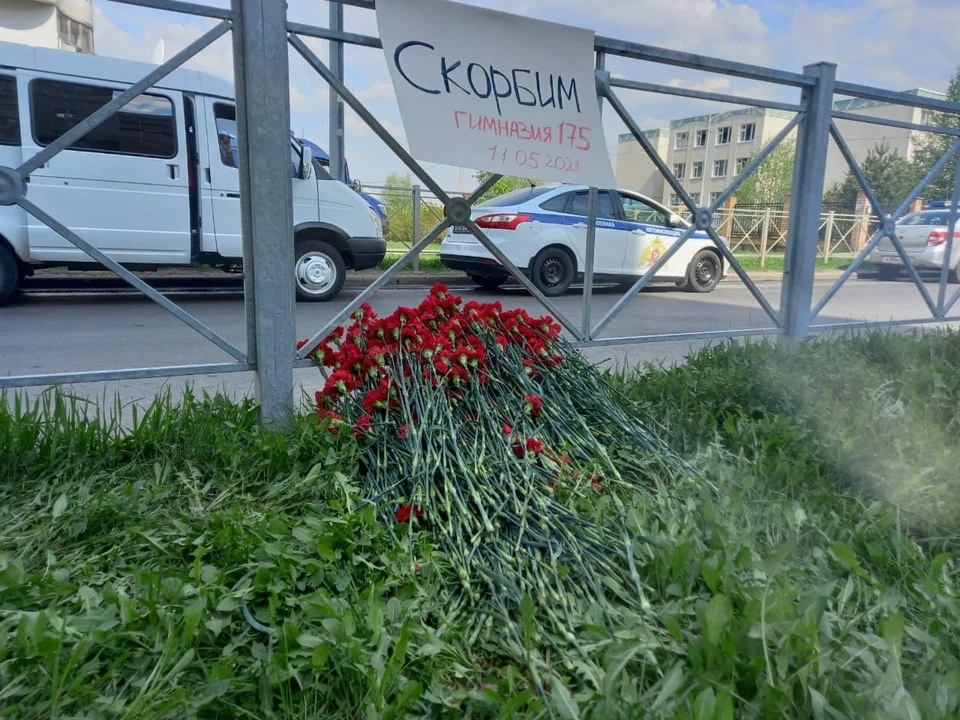Люди несут цветы к школе №175 в Казани. где бывший ученик устроил стрельбу