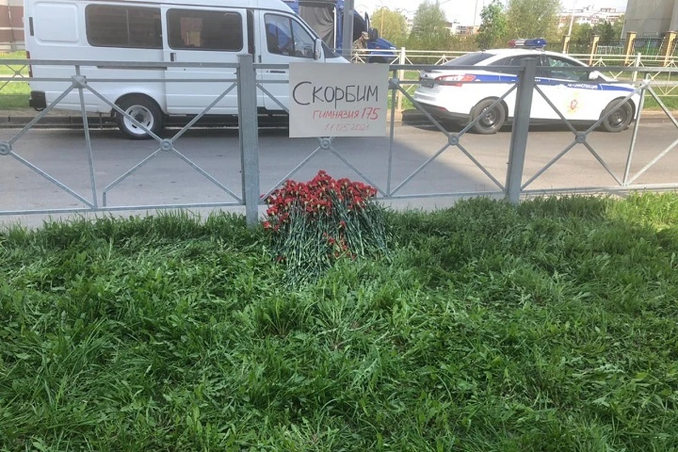 Горожане несут к школе цветы.