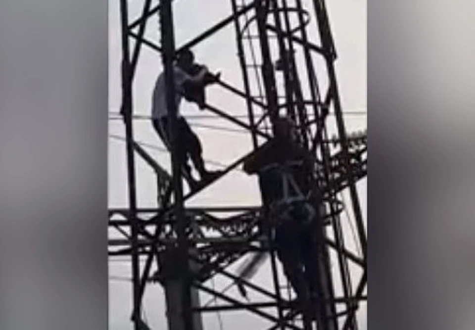 Спасателя помогли мужчине спуститься с мачты освещения. Фото: стоп-кадр