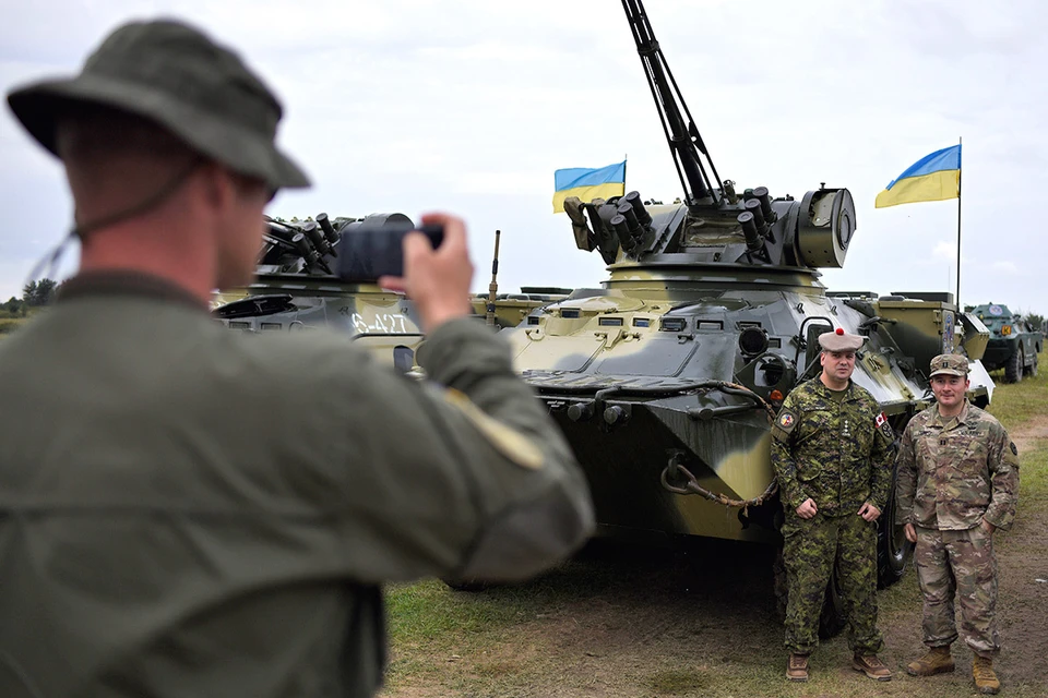 Солдаты НАТО фотографируются у украинской бронетехники во время совместных учений в Львовской области.