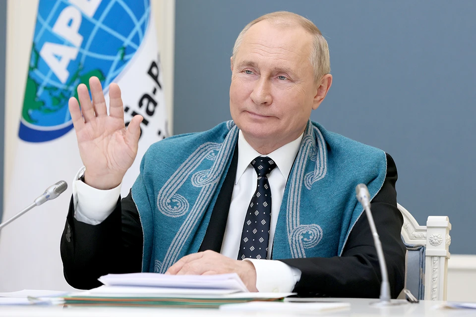 Владимир Путин предстал перед собеседниками в белой рубашке, классическом черном костюме с синим галстуком и голубой накидке из шерсти мериноса с белым узором. Фото: Михаил Метцель/ТАСС