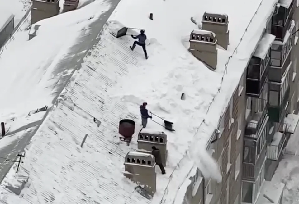 Мужчины не побеспокоились о своей безопасности, скидывая снег с крыши. Фото: «АСТ-54»