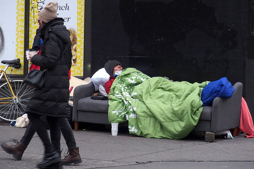 Бездомный мужчина спит под открытым небом, Нью-Йорк, США.