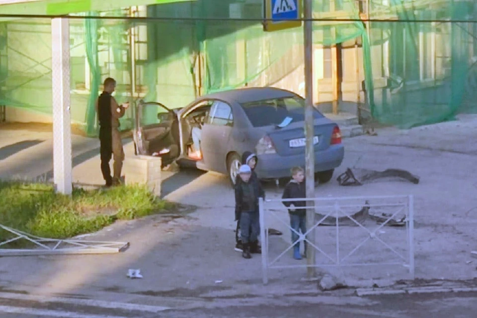 В Новосибирске девушка на седане протаранила ограду и въехала на тротуар. Фото: АСТ-54.