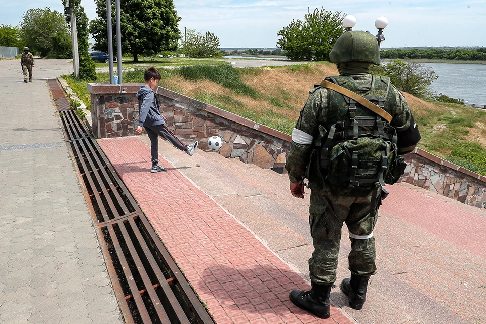 Херсон. Ребенок и российский военнослужащий на набережной города. Фото: EPA/SERGEI ILNITSKY/ТАСС