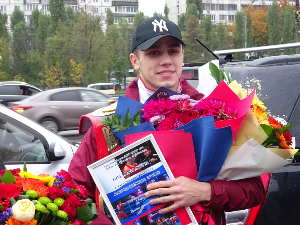 Игорь Свиридченков с чемпионским поясом и букетами цветов.
