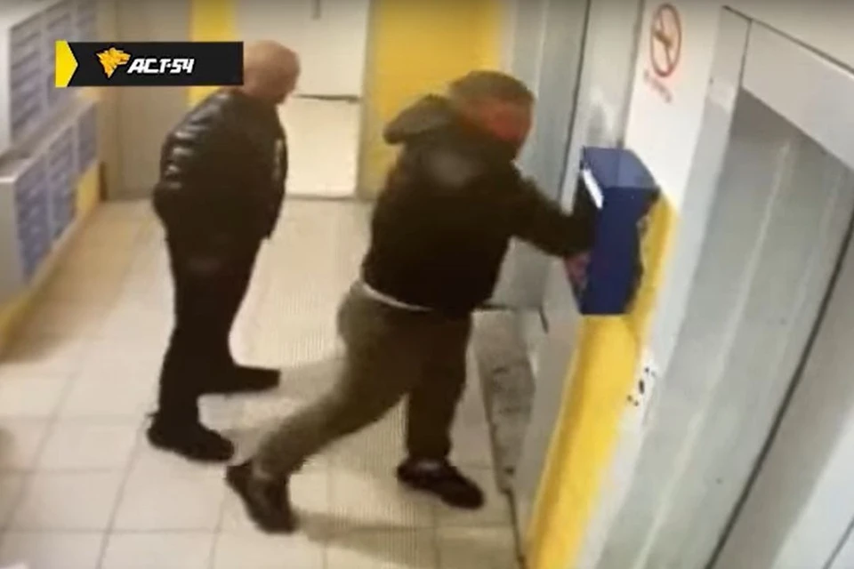 Двое пьяных мужчин разломали почтовый ящик в подъезде жилого дома в Новосибирске. Фото: стоп-кадр из видео / АСТ-54