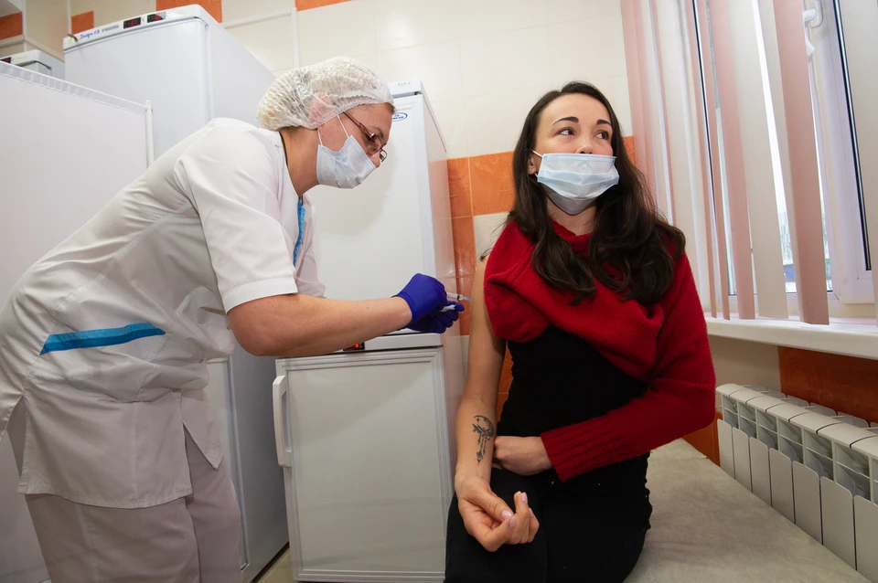 Санкт-Петербург. Медсестра делает девушке прививку от коронавирусной инфекции Covid-19 в прививочном пункте больницы.