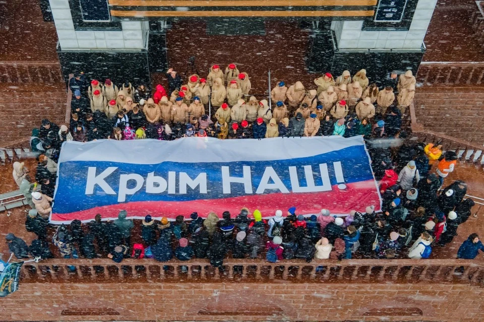 Участники акции растянули многометровый триколор с надписью «Крым наш». Фото: Telegram-канал «Агентство по делам молодежи Сахалинской области»
