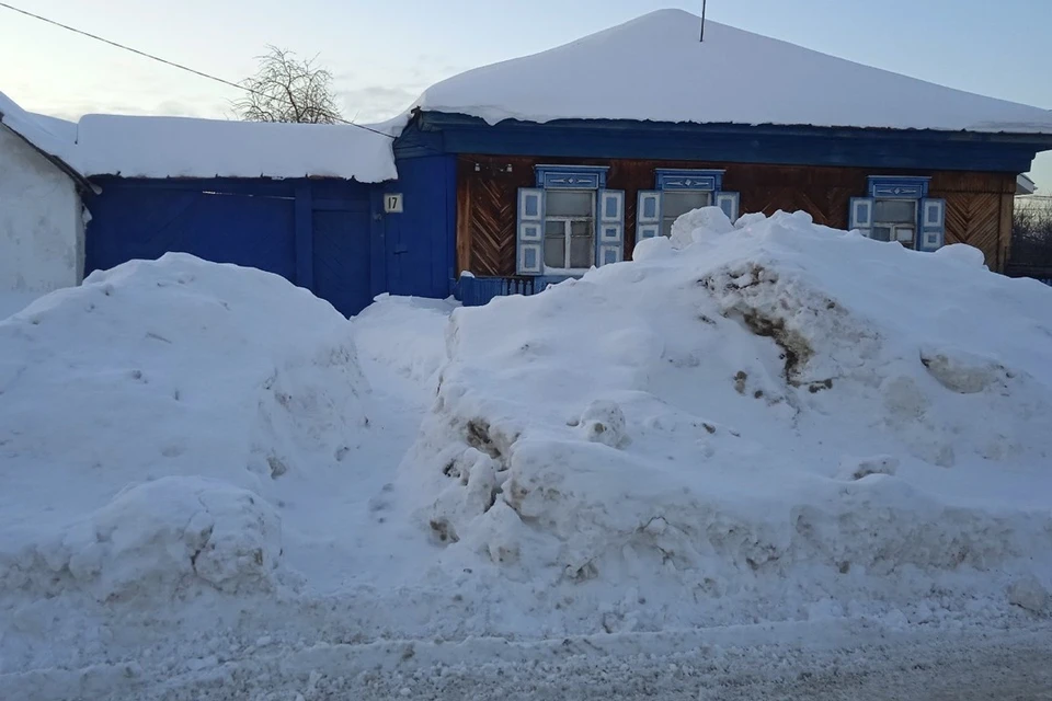 Вокруг дома огромные сугробы, но тропка к воротам почищена.