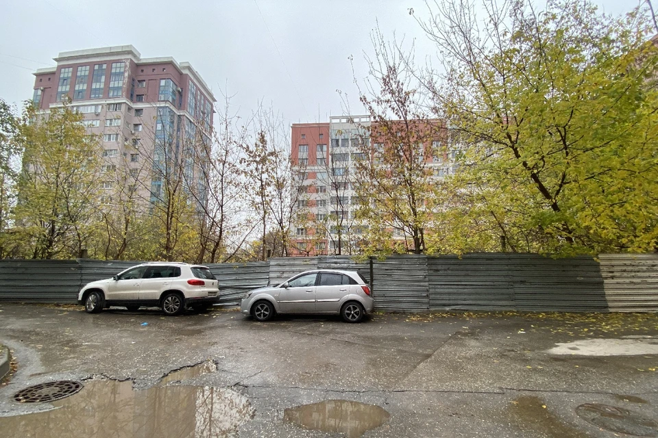 Котлован, огороженный забором, находится в центре нескольких дворов.