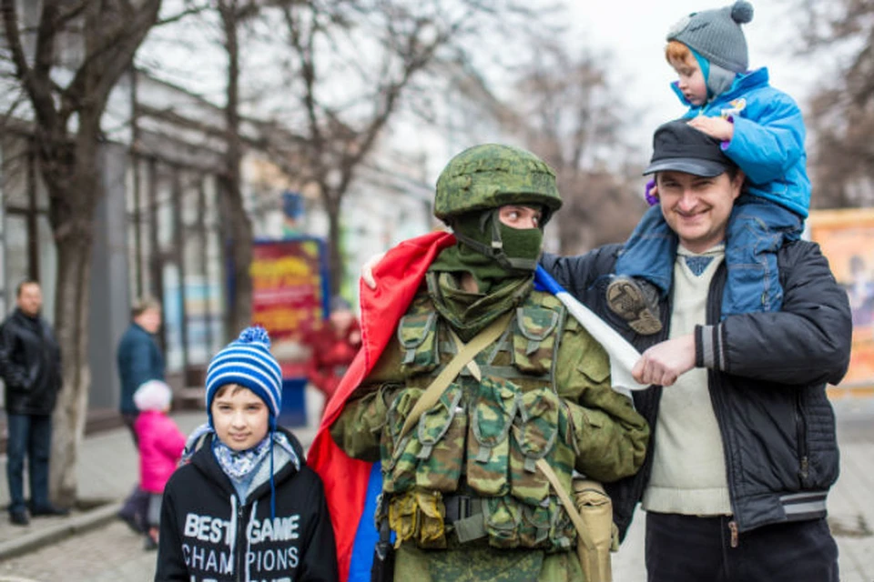 Жители Симферополя фотографируются с военным.