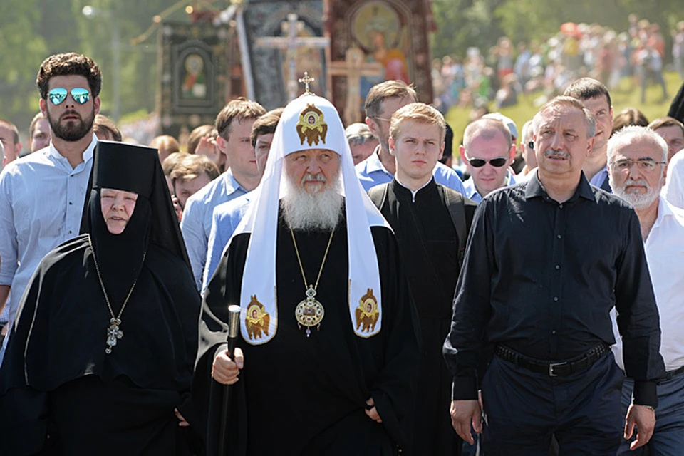 Впереди, опираясь на посох, и под белым зонтиком бодрым шагом шел Патриарх Кирилл