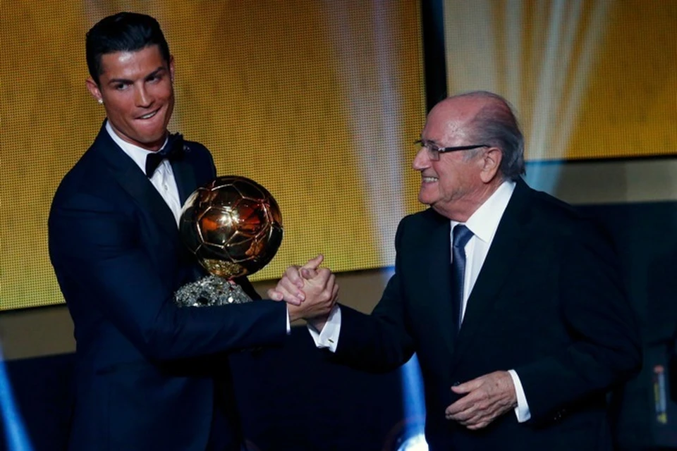 Роналду получает "Золотой мяч" из рук президента ФИФА.