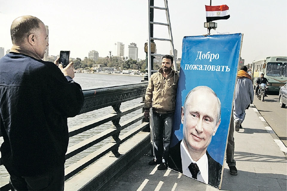 К визиту Владимира Путина улицы Каира украсили баннерами с портретами российского президента. Жители египетской столицы с удовольствием фотографируются рядом.