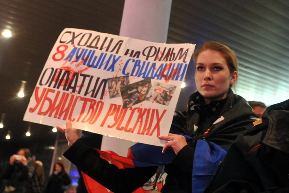Прямо напротив входа, завернувшись в флаг Новороссии, стояла известная активистка Национального фронта Мария Катасонова