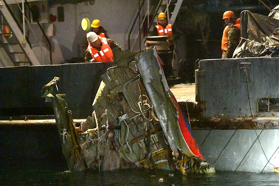 Спасатели поднимают фрагмент фюзеляжа рухнувшего в море лайнера.