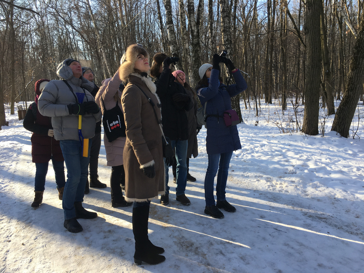 Zvenčí to opravdu vypadá nezvykle. Na parkové uličce před prázdnou lavičkou stojí skupinka lidí s dalekohledem a bez hnutí se dívá jedním směrem. Jako by to byl flash mob.