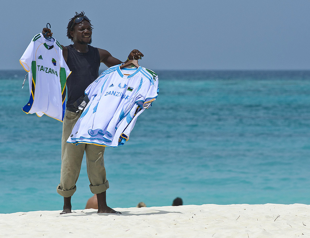 Занзибар, торговец футболками на пляже.