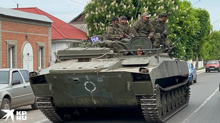 Рядом на улицах стоит российская военная техника.